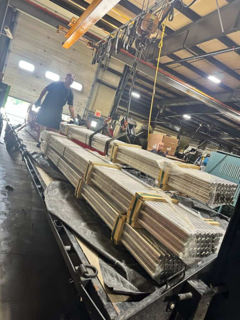 Flatbed trailer loaded with bundled metal rods in warehouse—Grey Cap’s proven reliability in industrial material handling.