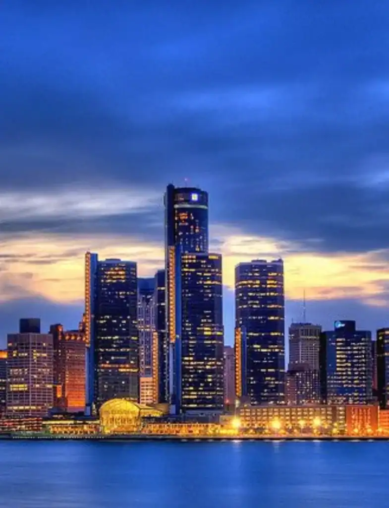 Renaissance Center and Detroit skyline reflected on river at dusk—Grey Cap service location in Detroit.