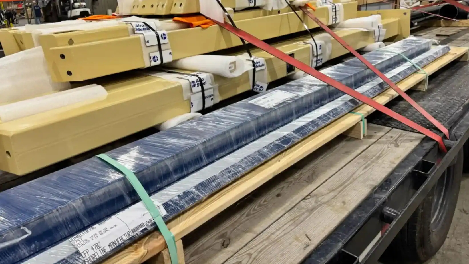 Trailer loaded with packaged metal components secured by colored straps—demonstrating Proven Reliability in Grey Cap’s industrial transport.