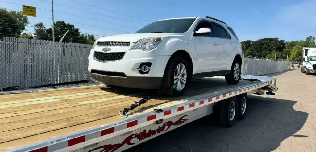 White Chevrolet Equinox SUV secured on flatbed trailer—Auto Transport by Grey Cap for safe vehicle relocation.
