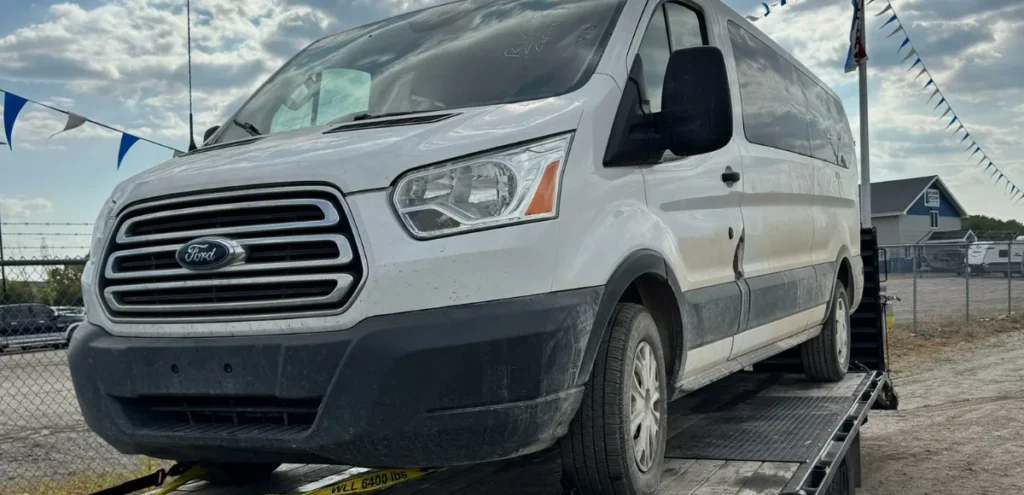 White Ford Transit van on flatbed trailer—Emergency Transport by Grey Cap for rapid vehicle relocation.