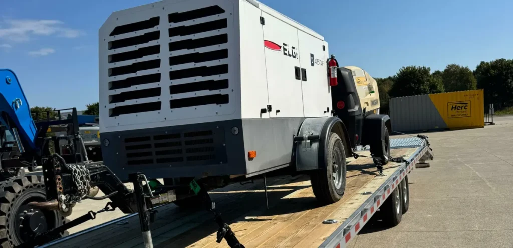ELGi D400T4 industrial air compressor secured on flatbed—equipment transport by Grey Cap at Fort Wayne for heavy-duty site operations.