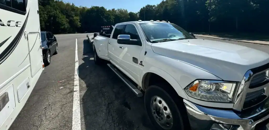 White dually pickup with trailer parked beside RV—Partial Truckload setup for flexible transport by Grey Cap